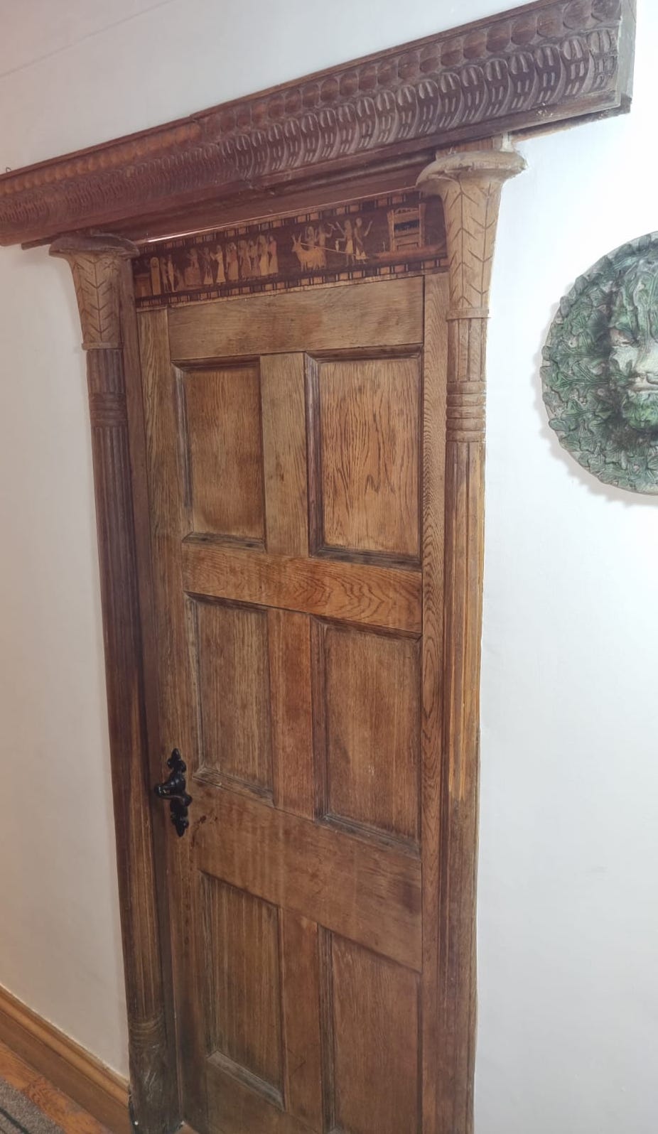 A panelled oak door with inset stained glass panels, width 78cm, height 194cm, another panelled door, sundry framework and assorted columns